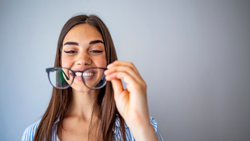 femme tenant des lunettes